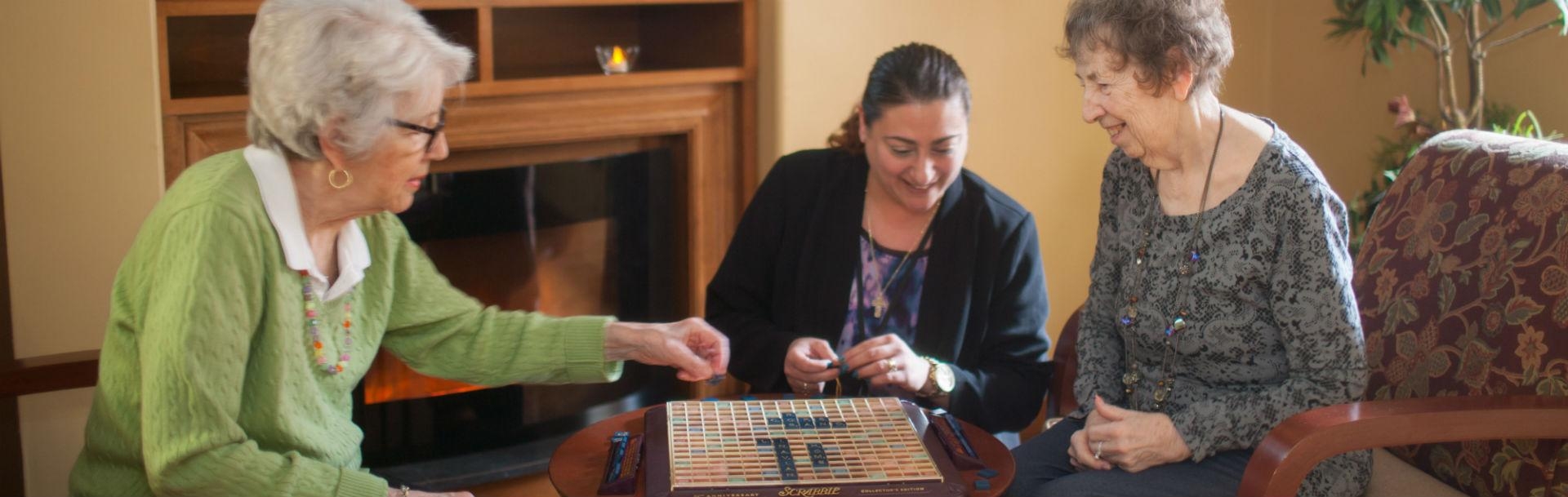 Our long term residents playing scrabble with staff